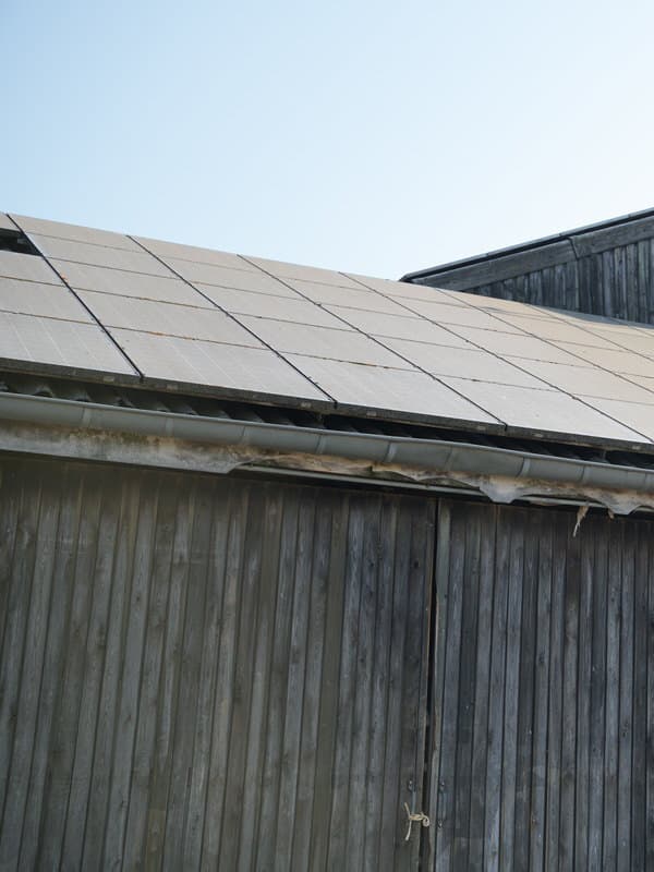 Verschmutzte Photovoltaik-Module auf einem Scheunendach vor der Reinigung – Staubfilm und Ablagerungen an den Modulrahmen